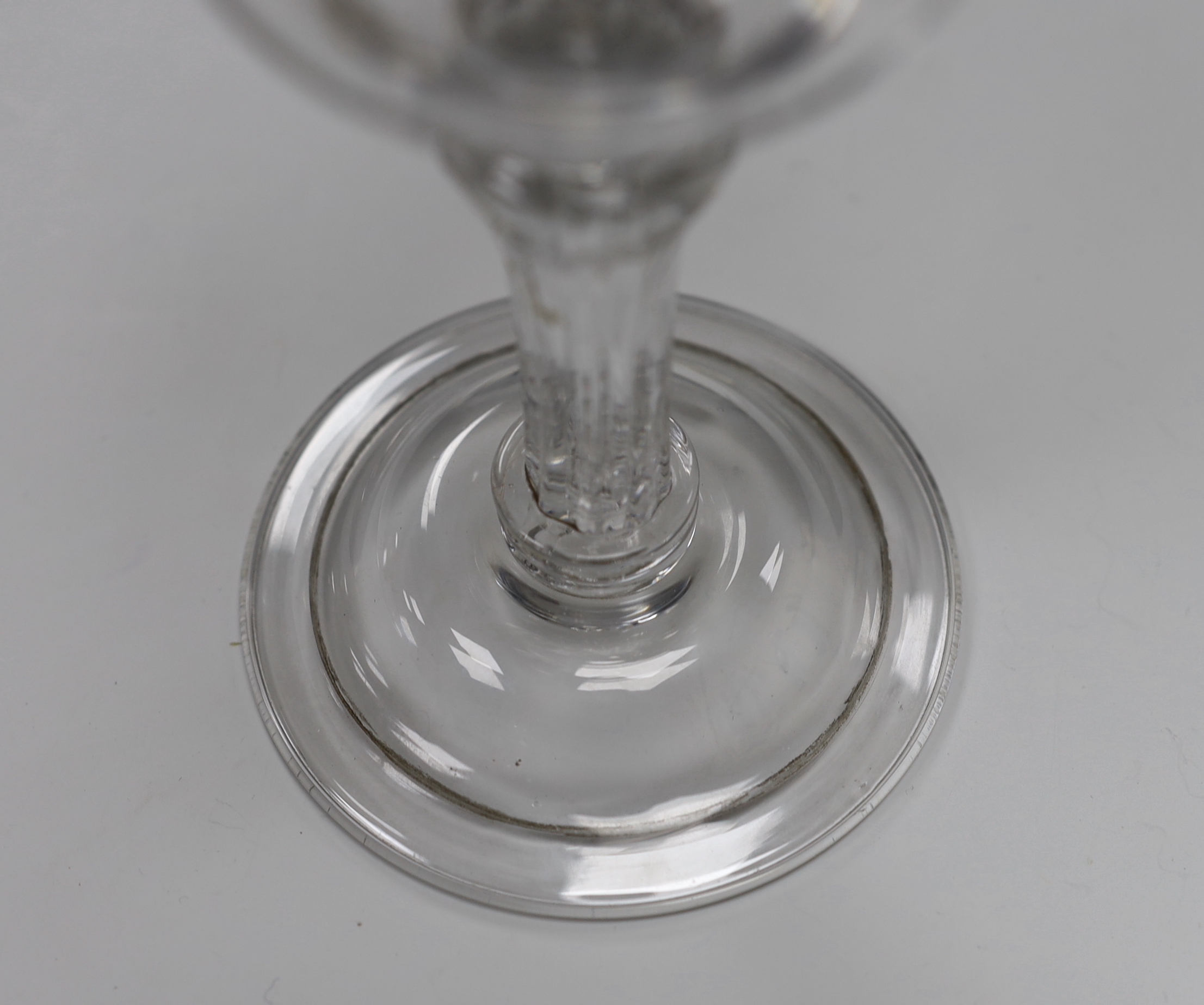 An English lead crystal champagne or sweetmeat glass c.1740, with double ogee bowl, with collar under the bowl, over a twelve sided debased, moulded pedestal stem over two collars at the base, with domed, folded foot and